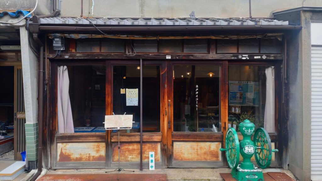 住宅街にあるネクタイコーヒーは、ガラスのスライド扉が特徴。緑色のコーヒーミルが目印で、大正時代の古民家を改装した落ち着いた雰囲気のカフェ。