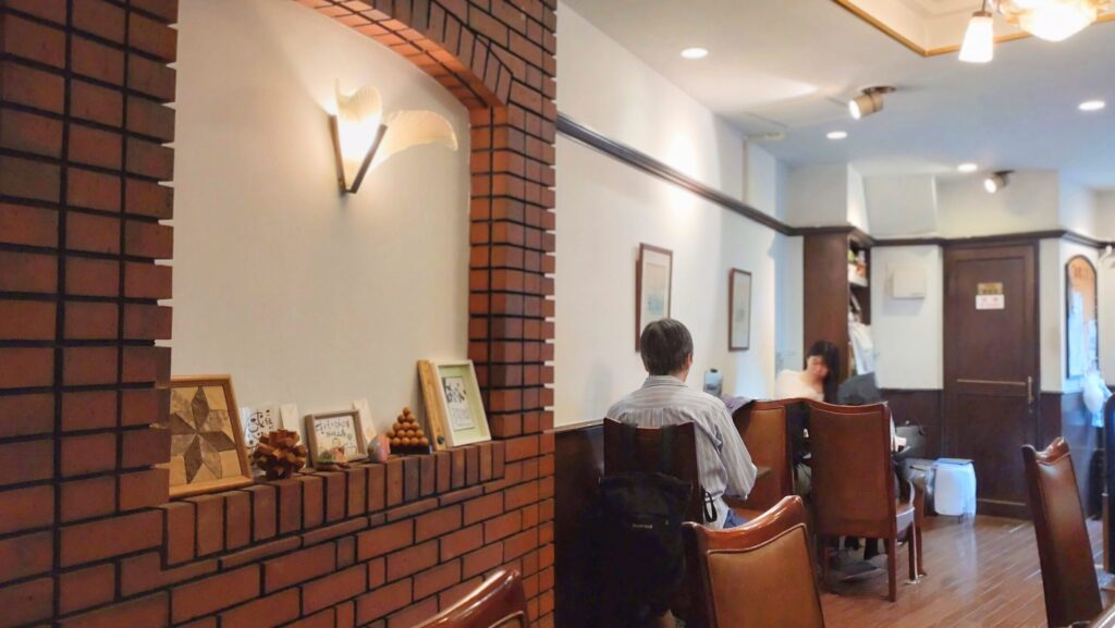 壁のレンガが印象的な珈琲工房の店内。清潔感があり居心地のよい喫茶店。